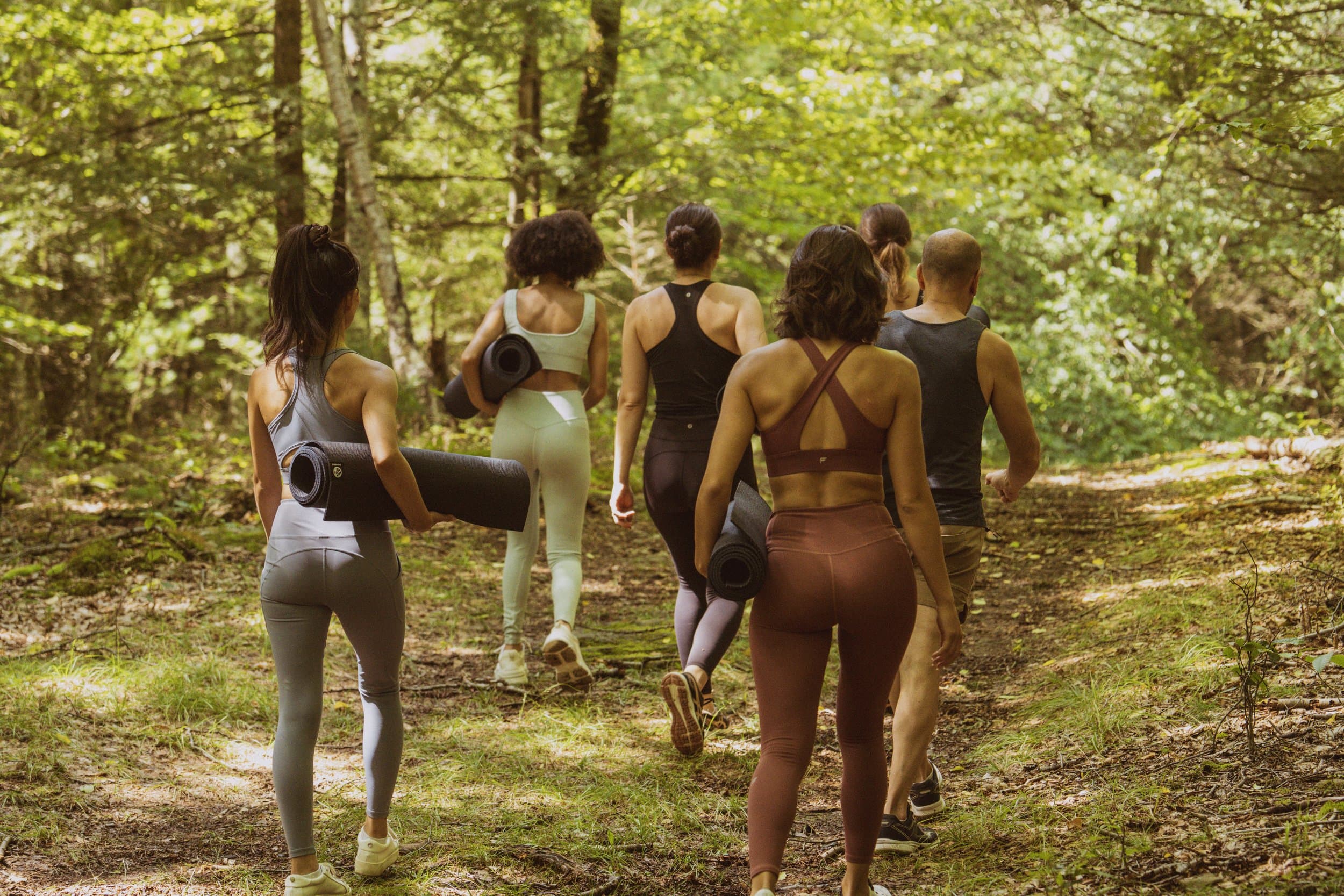 group of people heading to do yoga in forest
